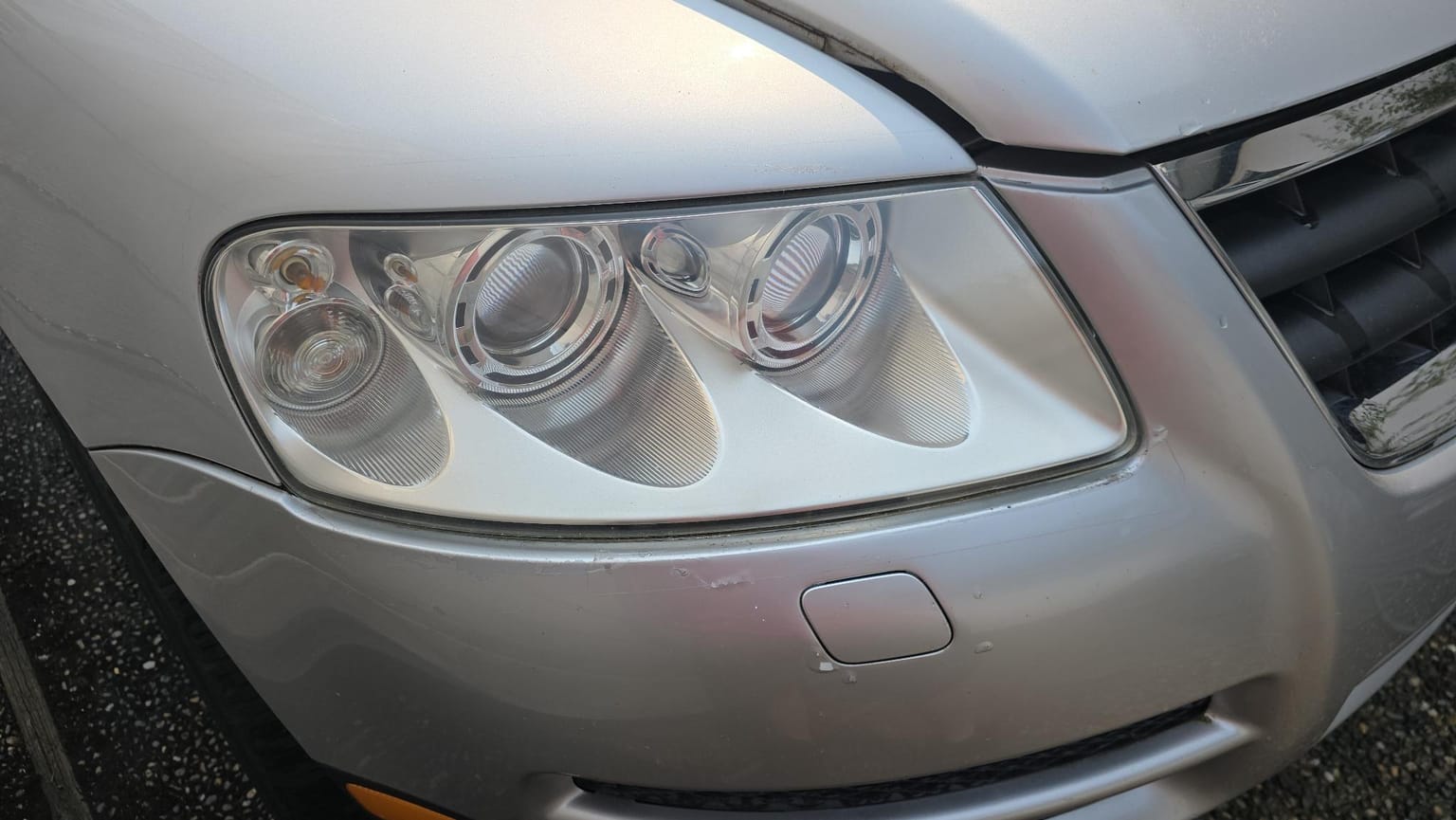 The same headlight after restoration: the lens is clear and the projector and reflector housings inside are sharply visible.